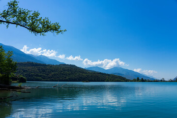 Toblino lake, Trentino Alto Adige. Marvelous large mountain lake in the hills of northern Italy. Flat water surface and clear blue sky. Popular swimming lake.