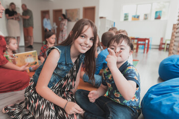 A girl and a boy with Down's syndrome in each other's arms spend time together in a preschool...