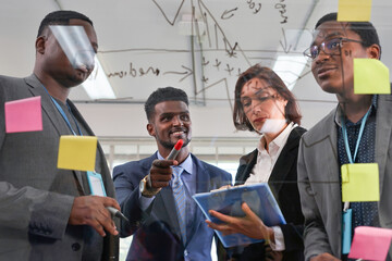 business people meeting and brainstorming discuss strategy by sticky note on transparent glass board(selective focus at a man)