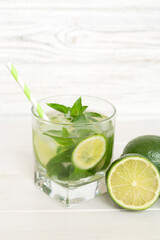Fototapeta premium Mojito cocktail. Refreshing mojito cocktail with lime, lemon and mint in a tall glass with a stick