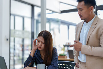 portrait of a female marketing worker showing a worried expression after being reprimanded by a male business owner for failing to meet the company's sales targets