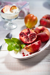Frisches Obst mit Joghurt im Glas auf weissem Tisch