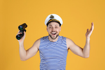 Happy sailor with binoculars on yellow background