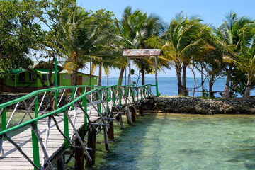 A tiny remote tropical island with a wooden boardwalk footbridge over stunning ocean in Pohnpei,...