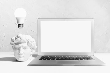 Idea and brainstorming abstract concept - image of creativity process as glow light bulb over head of white thinking statue David and blank screen notebook mockup. Idea of thinking, research solution.