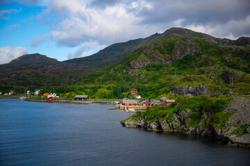 Typical red Norwegian fishermen's cottages and mountain ranges in the background. The photo was taken in the Lofoten Islands