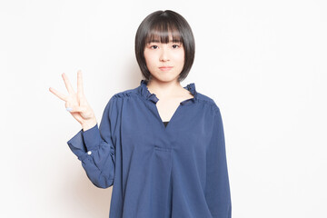 手で数字の3を示す女性