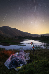 person sleeping in the mountain. Photograph under the stars. Perseids meteor shower in the mountains. camping in the wild