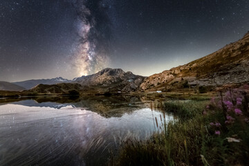 Milky way above a moutain lake. Mirror reflection of the milky way