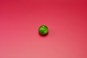 すだちを単体で中心に配置した赤系背景あり俯瞰撮影