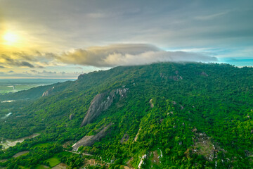 Obraz premium Morning on the top of Tri Ton mountain, An Giang, Vietnam when the clouds cover and the sun rises to welcome a peaceful new day in the border region of Vietnam