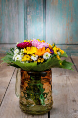 A bouquet of wild flowers on wooden table.