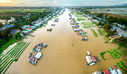 Floating village along Hau river over Vietnam border area, aerial view. The river basin contains a lot of seafood and alluvium for agriculture and economic development in the Mekong Delta