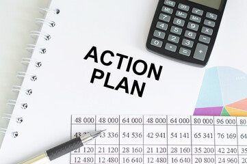 Action plan inscription on notepad next to documents, calculator and pen