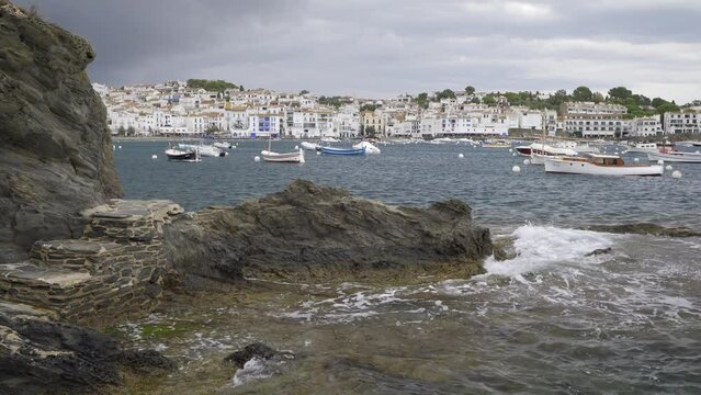 Static plane of a Seascape of the village of Cadaques in Girona, Catalonia, Spain. Stairs leading to the sea and the fishing village surrounded by small fishing boats docked in the port.
