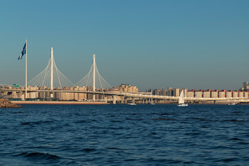 A cable-stayed bridge above the neva bay against a Saint Petersburg cityscape and the sky by summer day