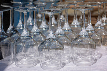 Banquet and catering concept, Upside down of shining wine glass in outdoor party, Row of glasses in the line on the counter bar, Layout buffet table with white tablecloth, Food and beverage background
