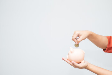 business woman hand hold piggy bank and putting coin with concrete wall for financial and saving money concept with concrete background and blank copy space.