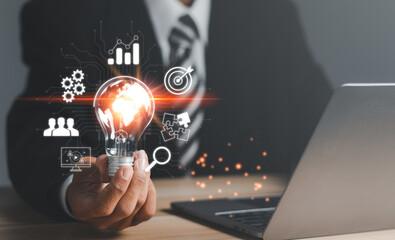 Businessman holding light bulb and virtual Global Internet connection inside . Concept of Ideas for presenting new ideas Great inspiration and innovation new beginning.