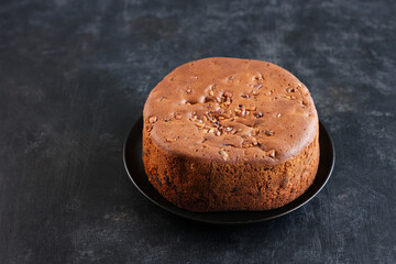 Woman serving homemade Christmas plum cake in black background India Kerala. Fruitcake of dried fruit, nuts, spices , rum New Year party, Easter, Christmas Eve. Indian Christmas celebration