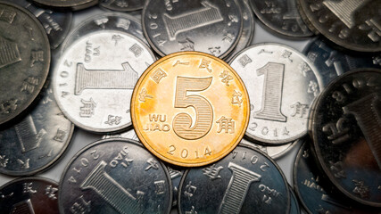 A close-up shot of a yellow Chinese five jiao coin. In the background there are a lot of 1 Chinese...