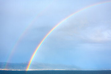 Seaside rainbow . Natural phenomenon . Rain and sunny weather