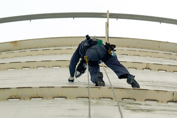 Male worker rope access height safety inspection of thickness storage oil and gas tank industry