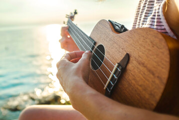 women relaxing and playing on ukulele on beach, so happy and luxury in holiday summer, outdoors...