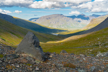 Vast mountain valley in remote Arctic on a sunny summer day. Noajdevagge valley with Laddebakte mountain in the back,Sarek National Park,Lapland,Sweden