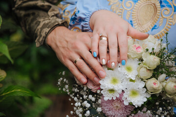 Fototapeta premium the Hands of brides with gold wedding rings close up 