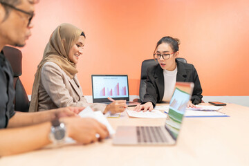 business muslim and asian woman and man have meeting. office woman explain project plan in future for organization and worker to work. talking team sitting in conference room to debate about company