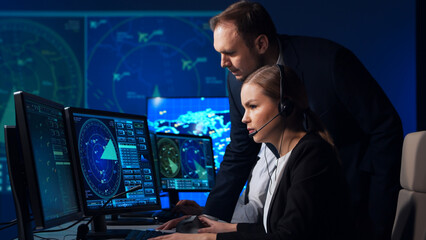 Workplace of the air traffic controllers in the control tower. Team of professional aircraft control officers works using radar, computer navigation and digital maps. Aviation concept.