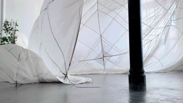 Installation with the parachute moving on the air in the photo studio.