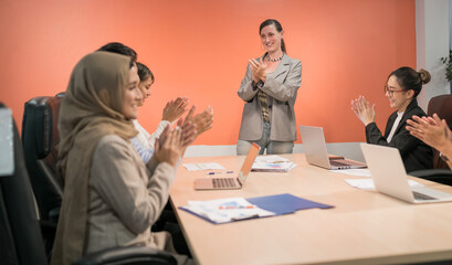 international male and female business group celebrate. an empower teamwork support organization boss for having high leadership. happy employee applause leader for success project in conference room