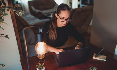 A young girl working from home in her home office and talking on phone about business