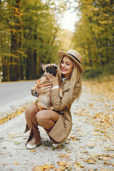 Young blonde girl walking with a little puppy french bulldog