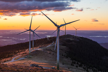 A group of wind power plants early in the morning while sunrise in Austria