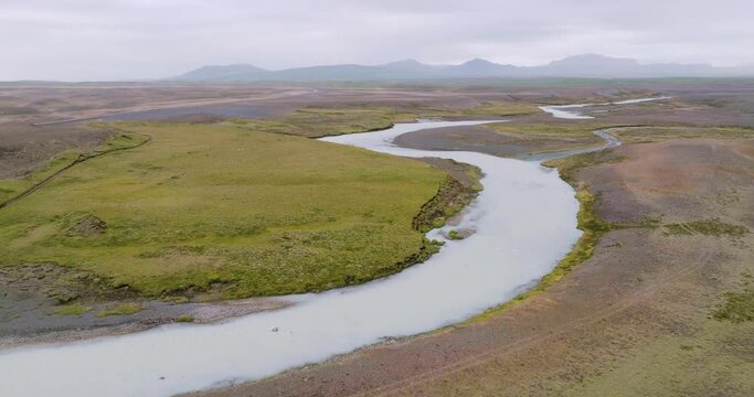 Aerial descending view of winding river Sanda in the desolate highlands of Iceland.