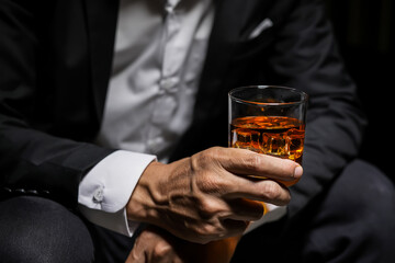 Closeup businessmen holding a glass of whiskey