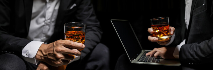Closeup businessmen holding a glass of whiskey