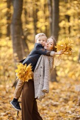 Mother and her son playing and having fun in autumn forest