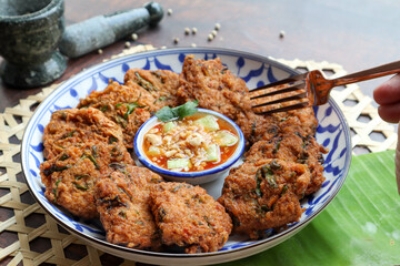 Thai fish cake or Fish cake ball - Thai food called Tod Mun Pla Krai with sweet chili dipping sauce at close up view