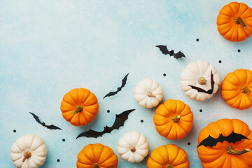 Halloween holiday background with party decorations of pumpkins and bats on blue top view. Happy...