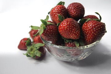Fresh strawberries in a transparent glass bowl