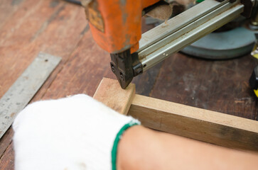 Young man doing woodworking hobby in his workshop, soft focus.