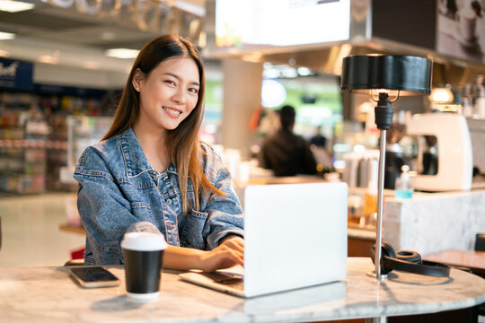 Happy Young Asian Traveller Female Sit Relax Waiting For Abroad Time In Cafe Restaurant At Airport Departure Terminal