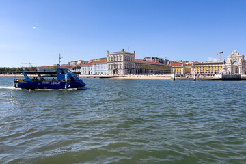 Naklejka premium Tour boat sailing by Praca do Comercio in Lisbon