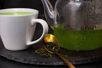 Teapot with green teas and tea leaves