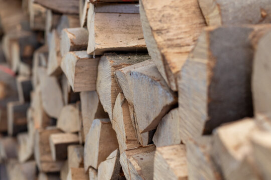 Seitenansicht eines Stapels Brennholz bestehend aus zahlreichen Holzscheiten aus gespaltenen St&auml;mmen der Buche f&uuml;r das Heizen in einem Kaminofen in Zeiten des Energiemangsl