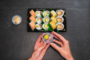 delicate hands opening box of wasabi to eat with sushi, healthy